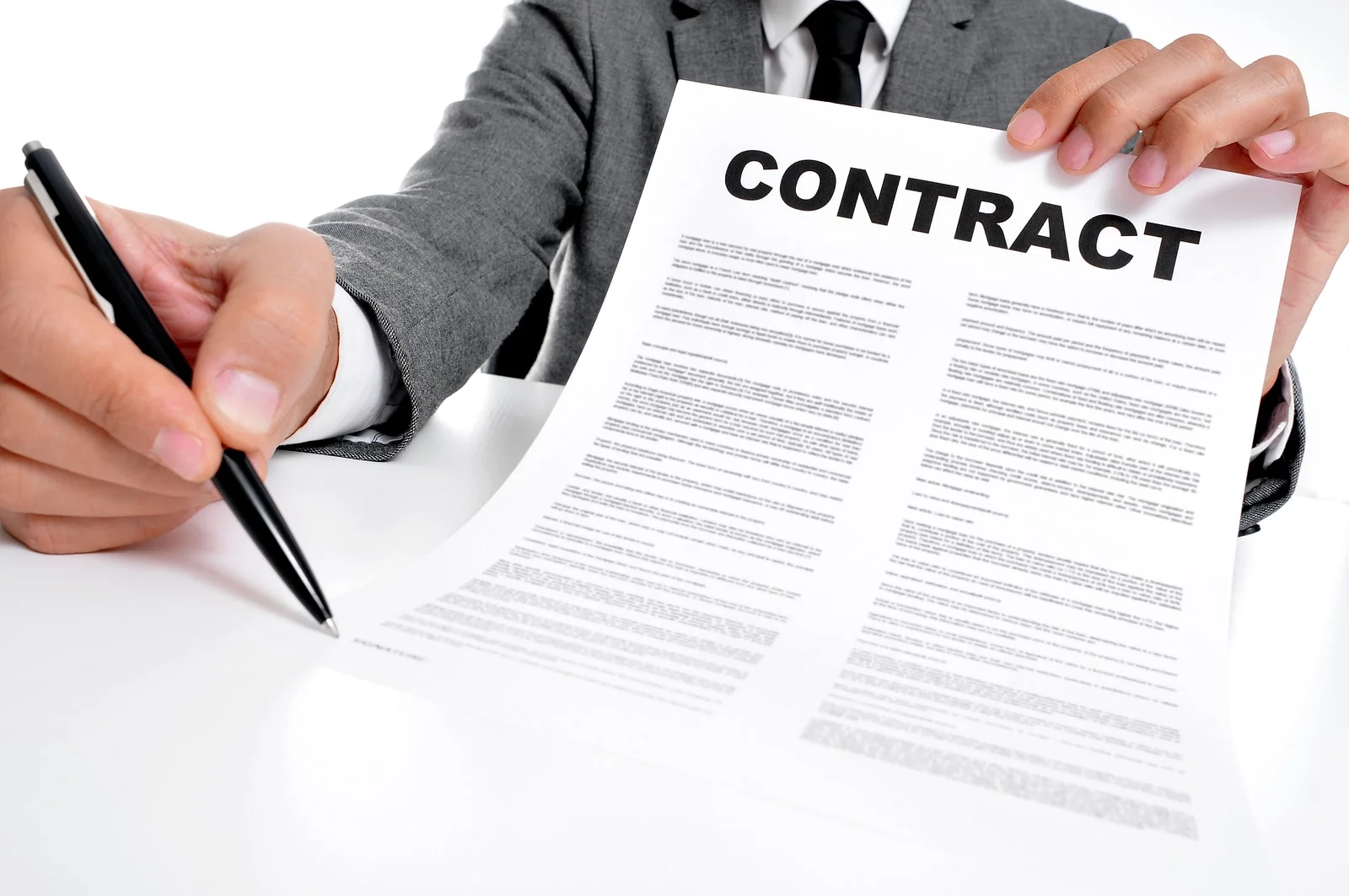 Man Wearing A Suit Sitting In A Table Showing A Contract And Whe